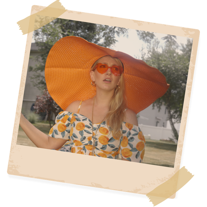 A picture of a woman wearing a large sun hat and sunglasses