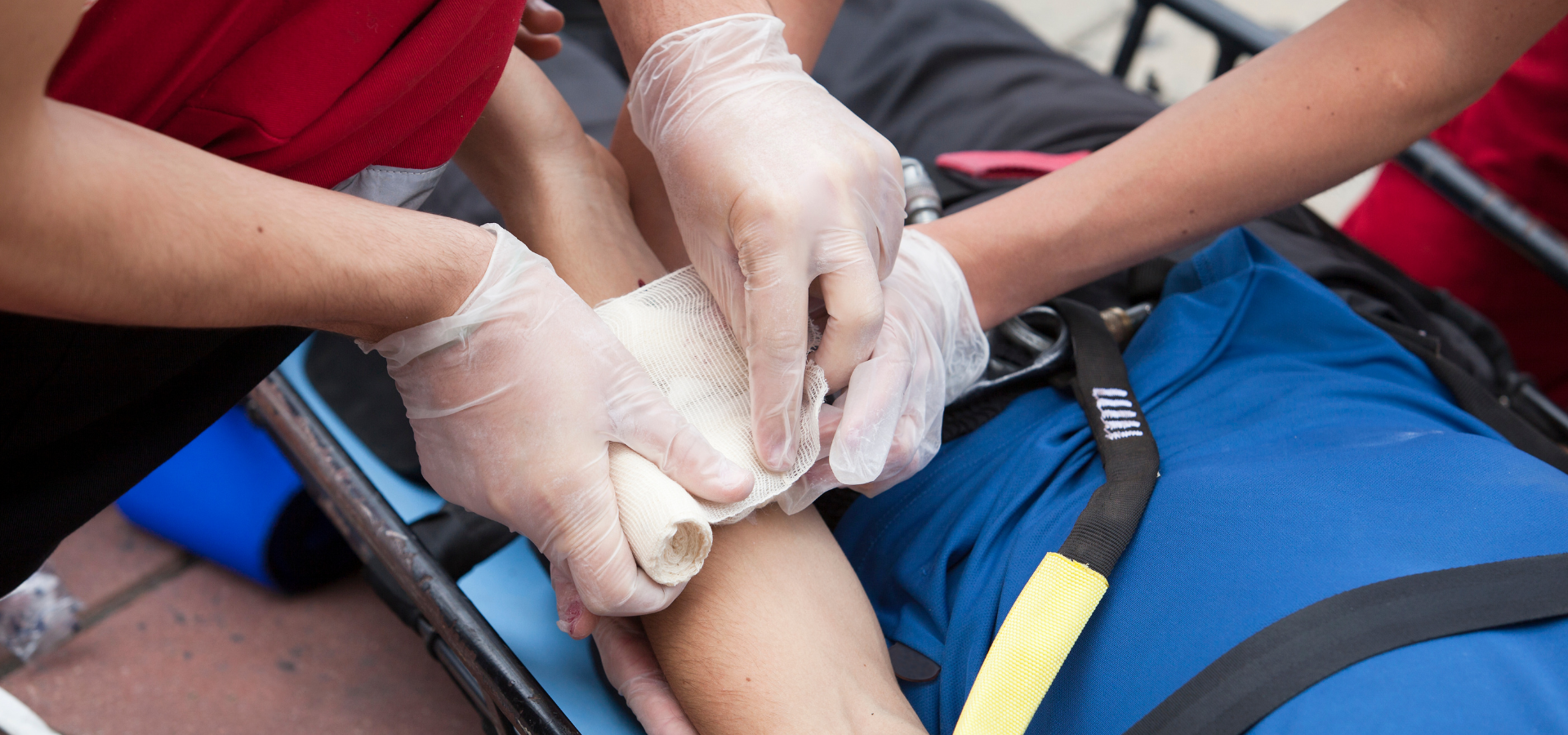 Rescuers applying a bandage to an injured person on a stretcher