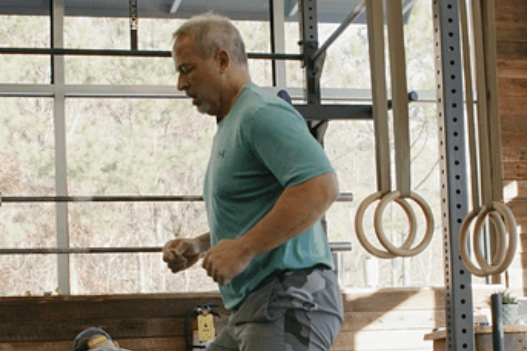 a man in a blue shirt is running in a gym .