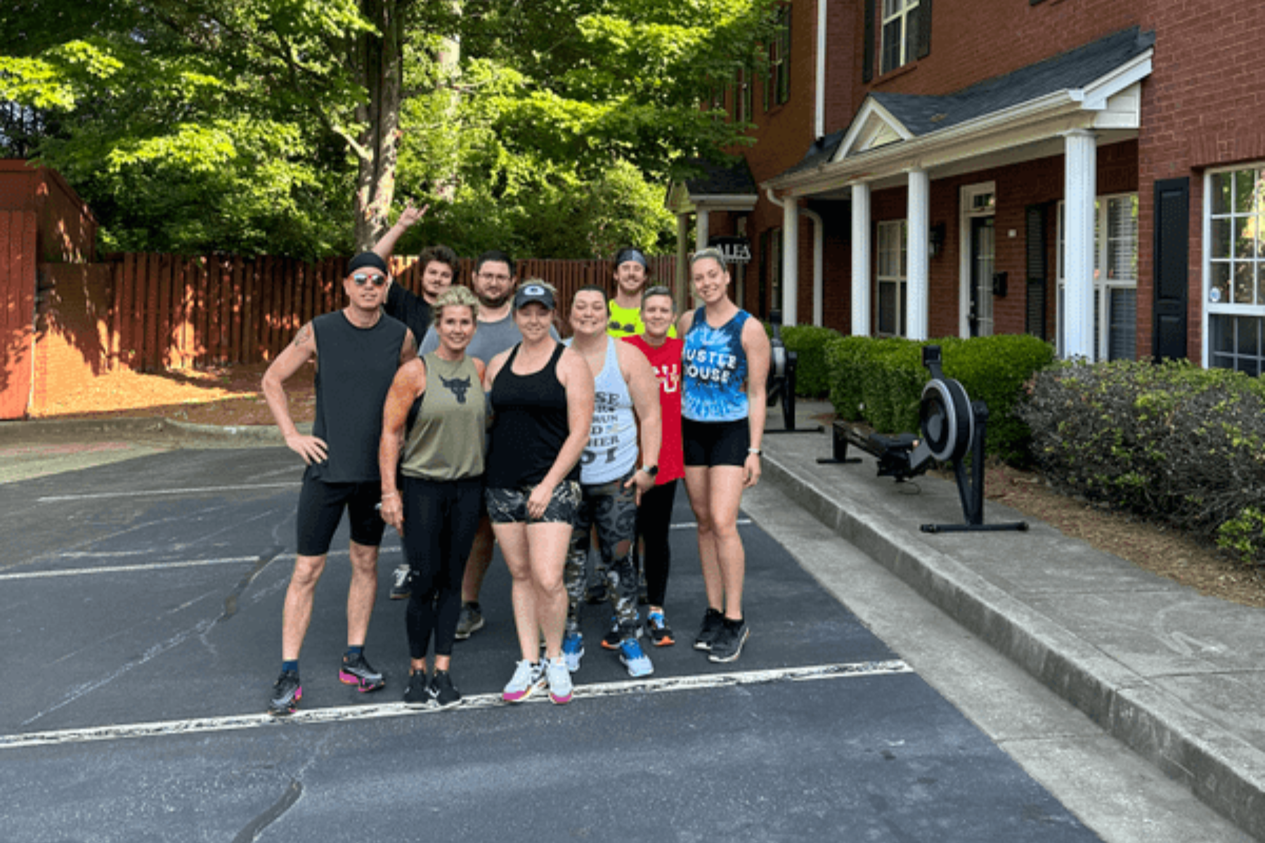 a group of people are posing for a picture in front of a brick building .