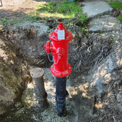 Red fire hydrant in an excavated pit.