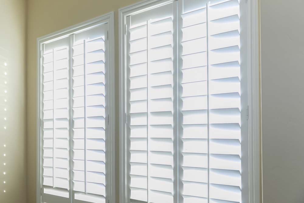 White Plantation Shutters On White Window