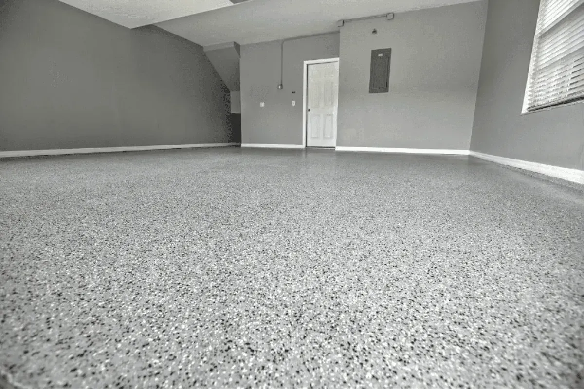 Empty garage with gray speckled epoxy floor and gray walls.