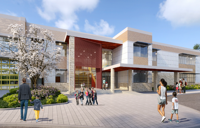 Modern building entrance with people; red brick accent, stone facade, sunny day.