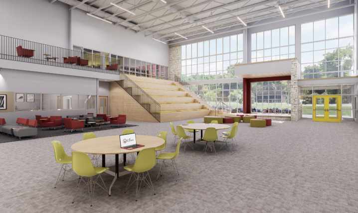 Modern open-concept library with tables, chairs, and tiered seating. Large windows let in natural light.