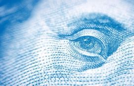 Close-up of the eye of Benjamin Franklin from a blue US $100 bill.