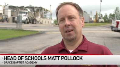 Head of Schools Matt Pollock of Grace Baptist Academy, wearing maroon, speaks outside a damaged building.
