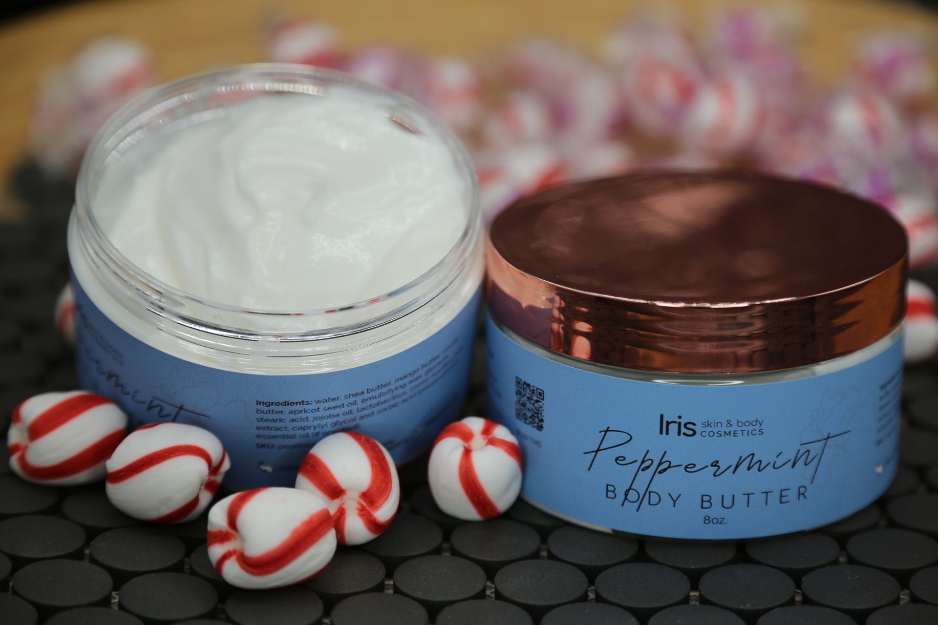 A jar of peppermint body butter surrounded by peppermint candies
