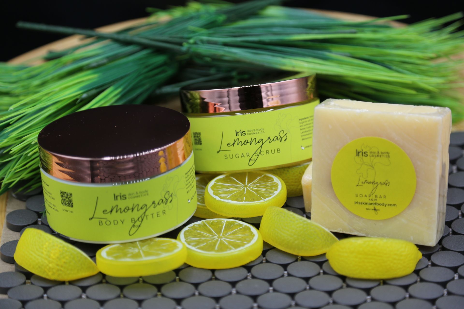 A jar of lotion , a bar of soap , and lemon slices on a table.