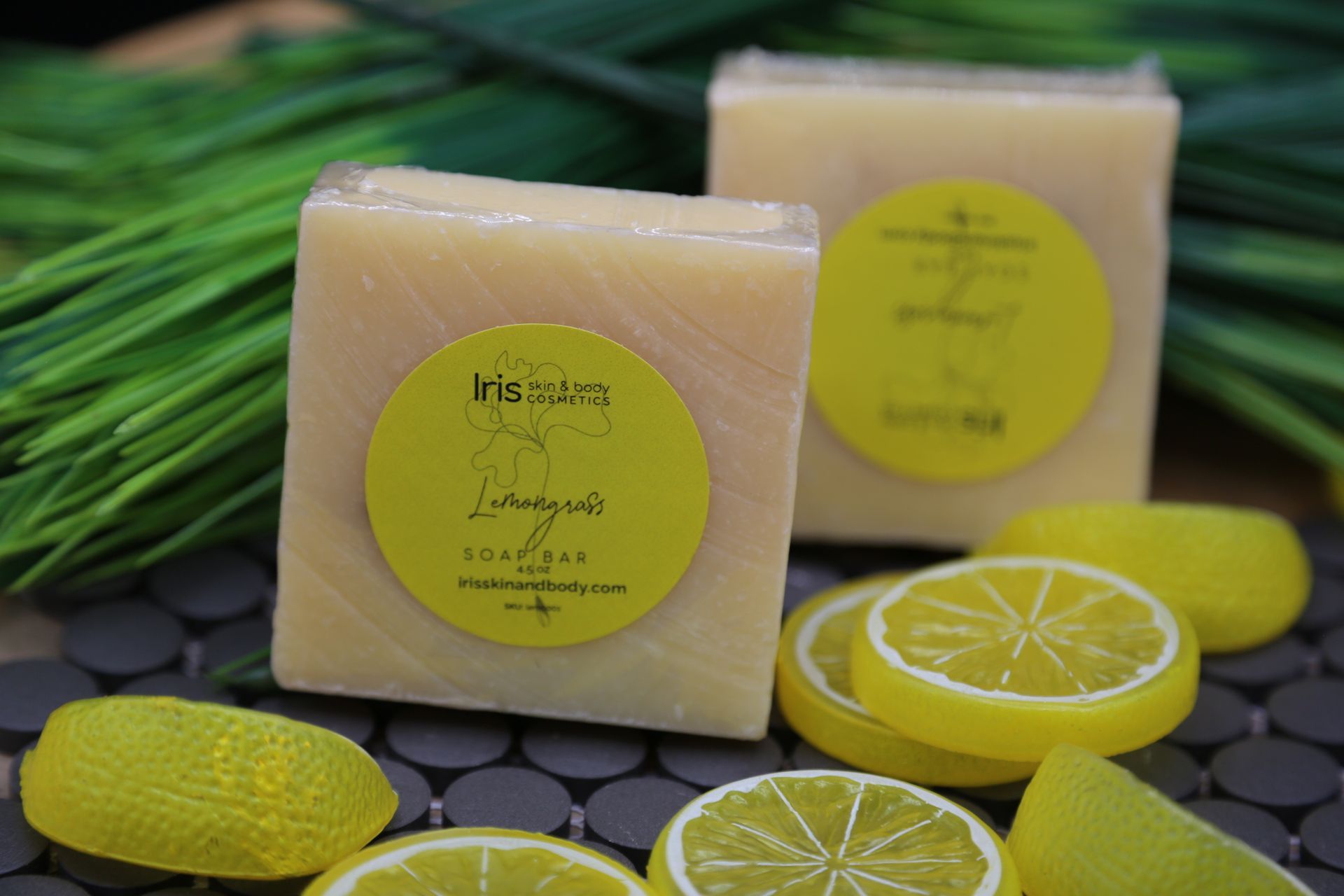 Two bars of soap are sitting on a table next to sliced lemons.