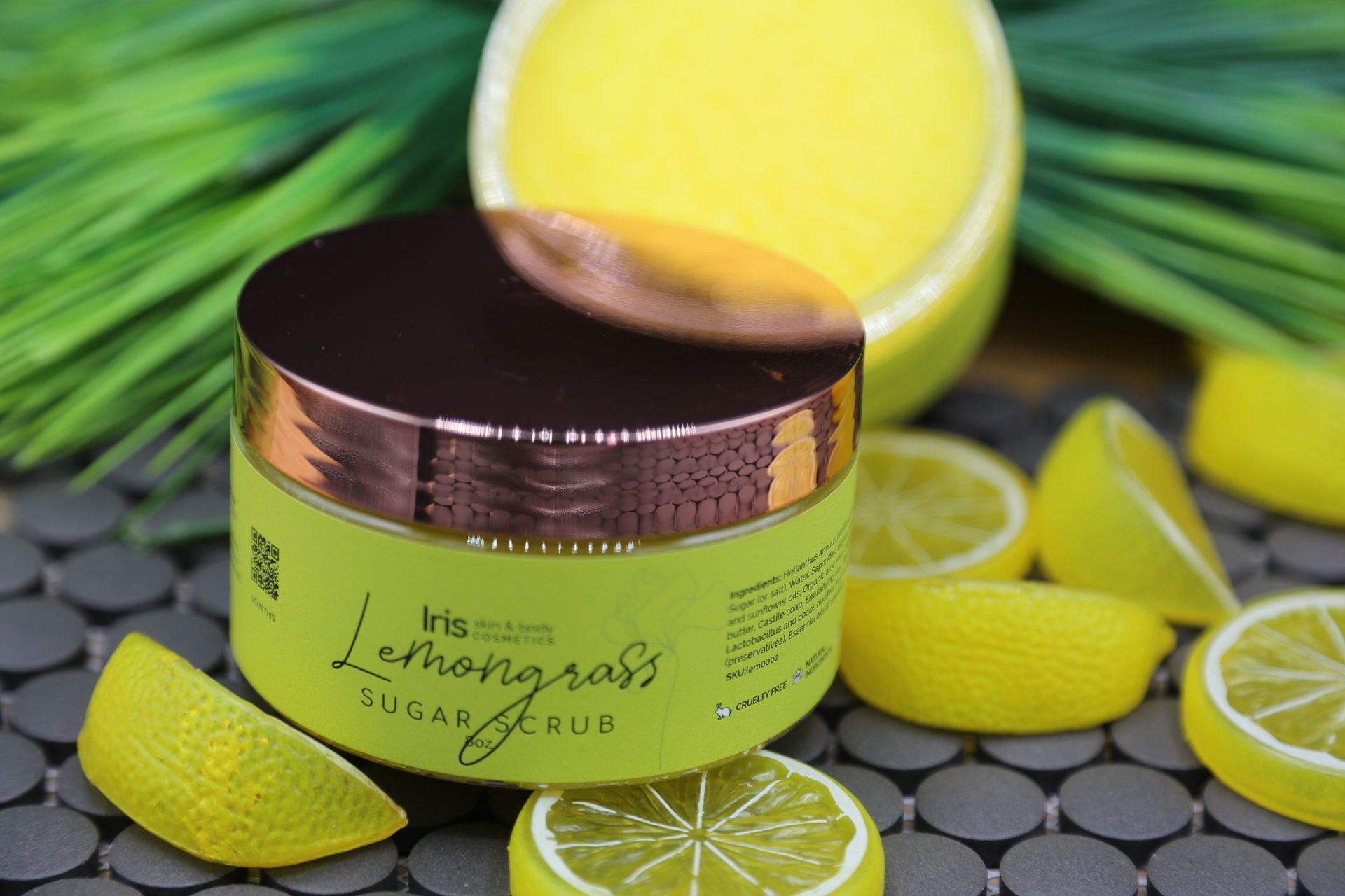 A jar of lemongrass sugar scrub surrounded by sliced lemons