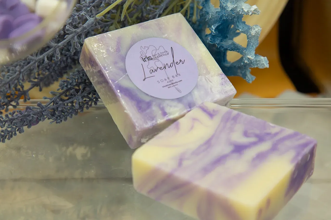 A purple and white soap bar is sitting on a glass table.