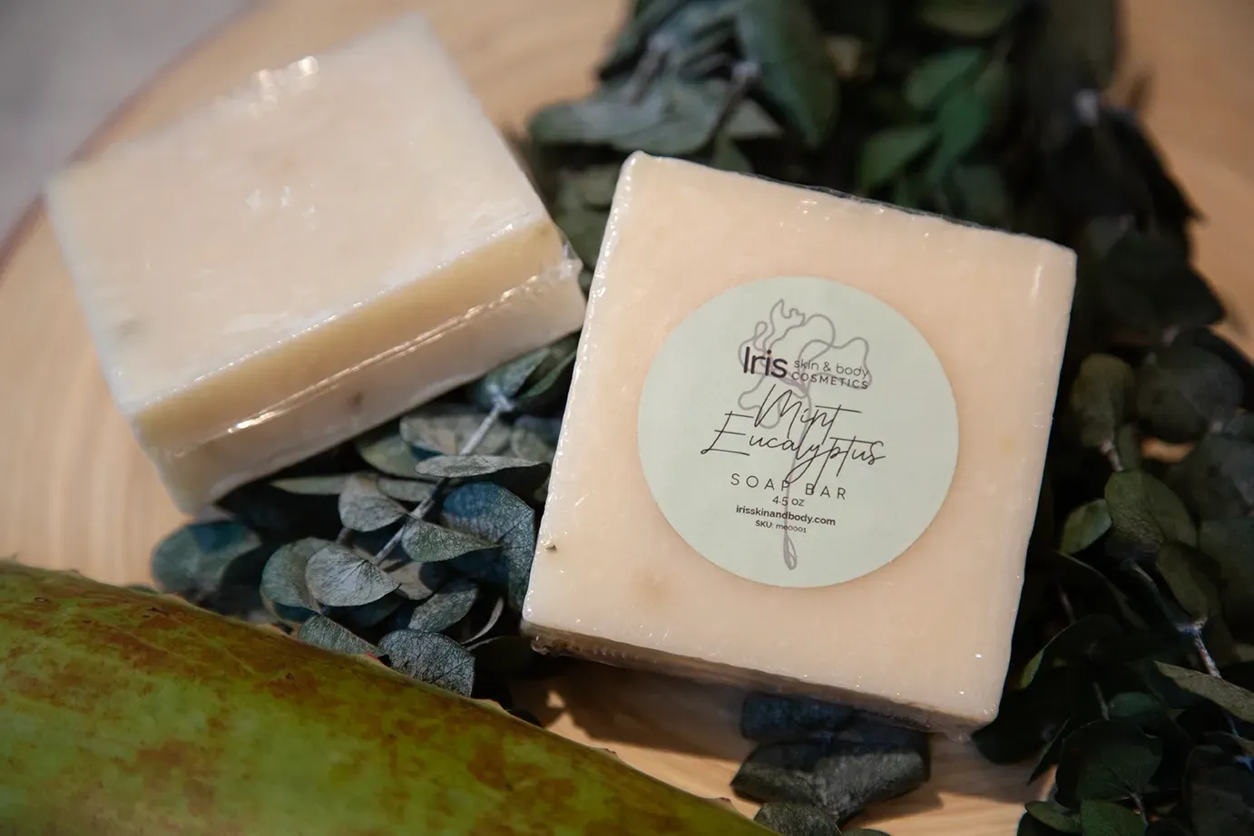 Two bars of soap are sitting on top of a wooden table.