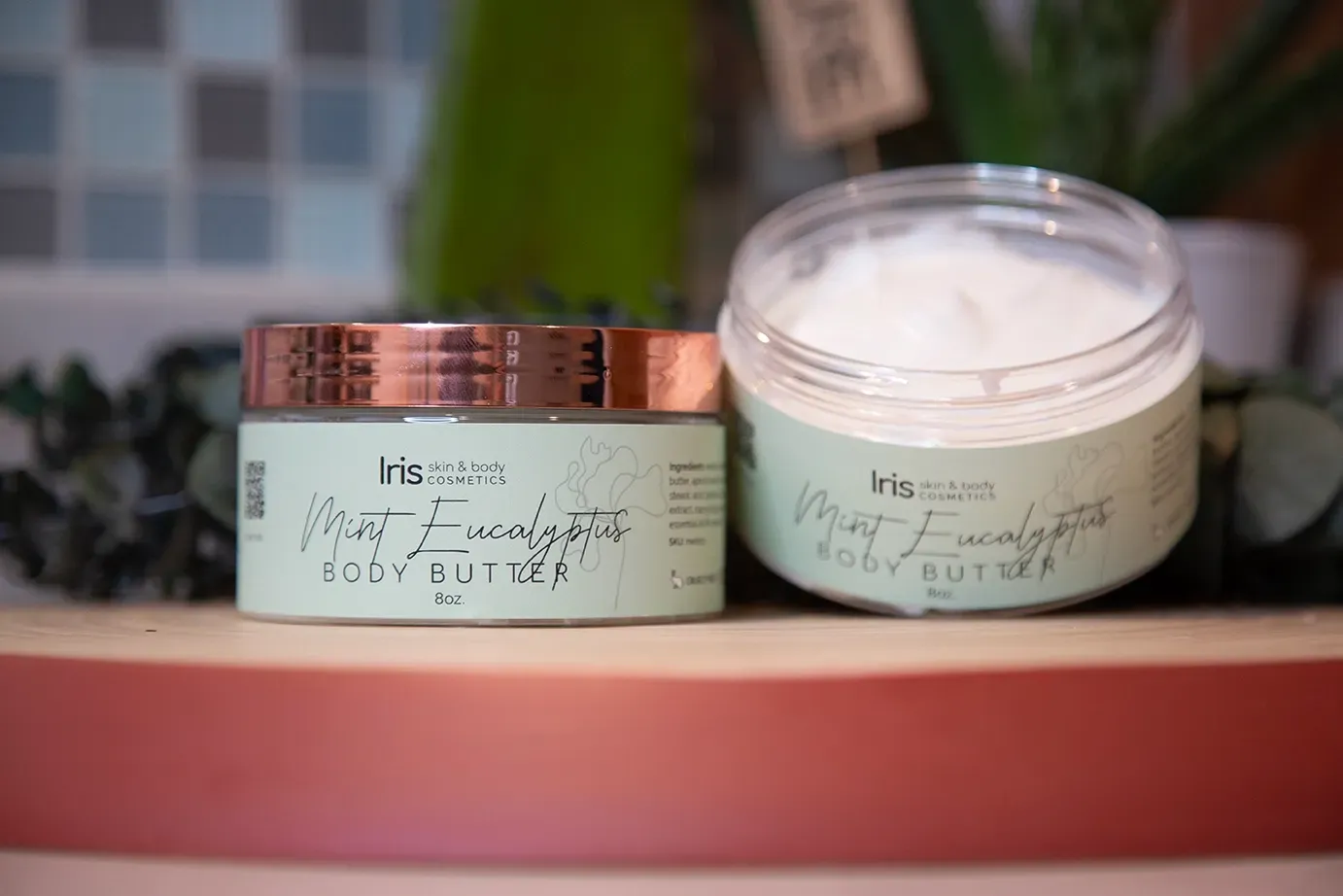 Two jars of body butter are sitting on a shelf.