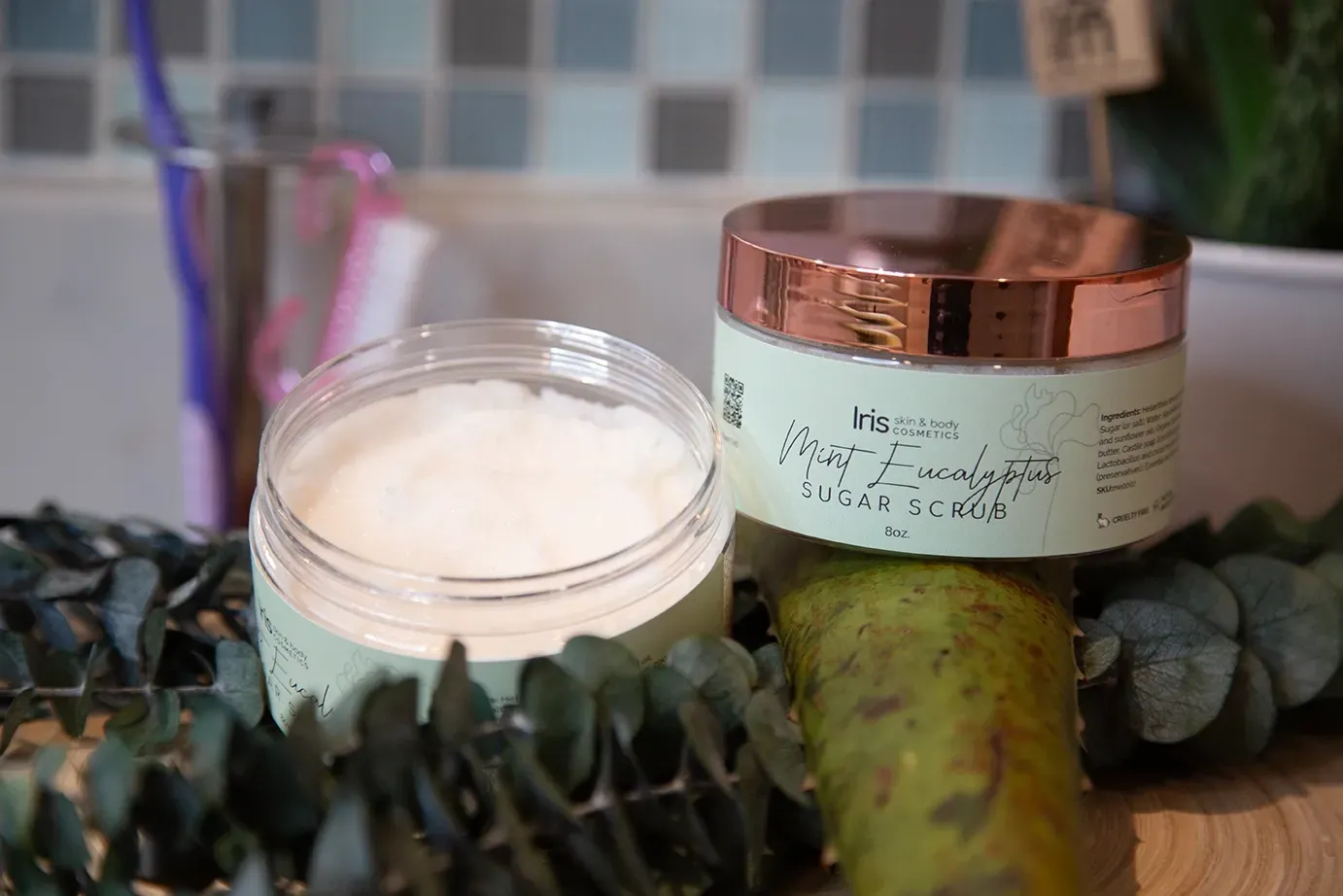 A jar of cream is sitting on a table next to a toothbrush.