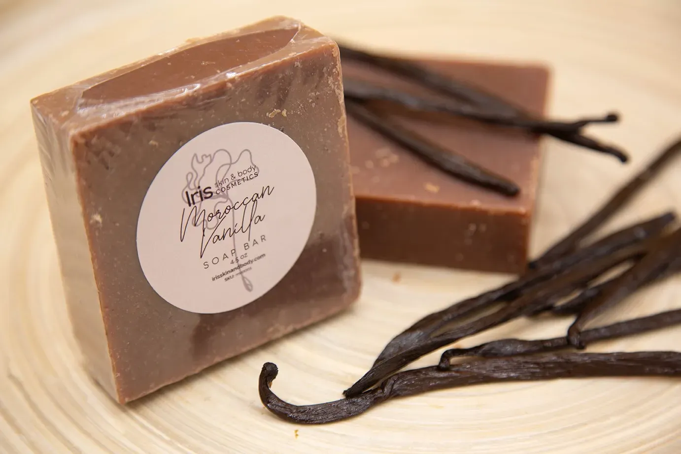 A bar of soap with vanilla beans next to it
