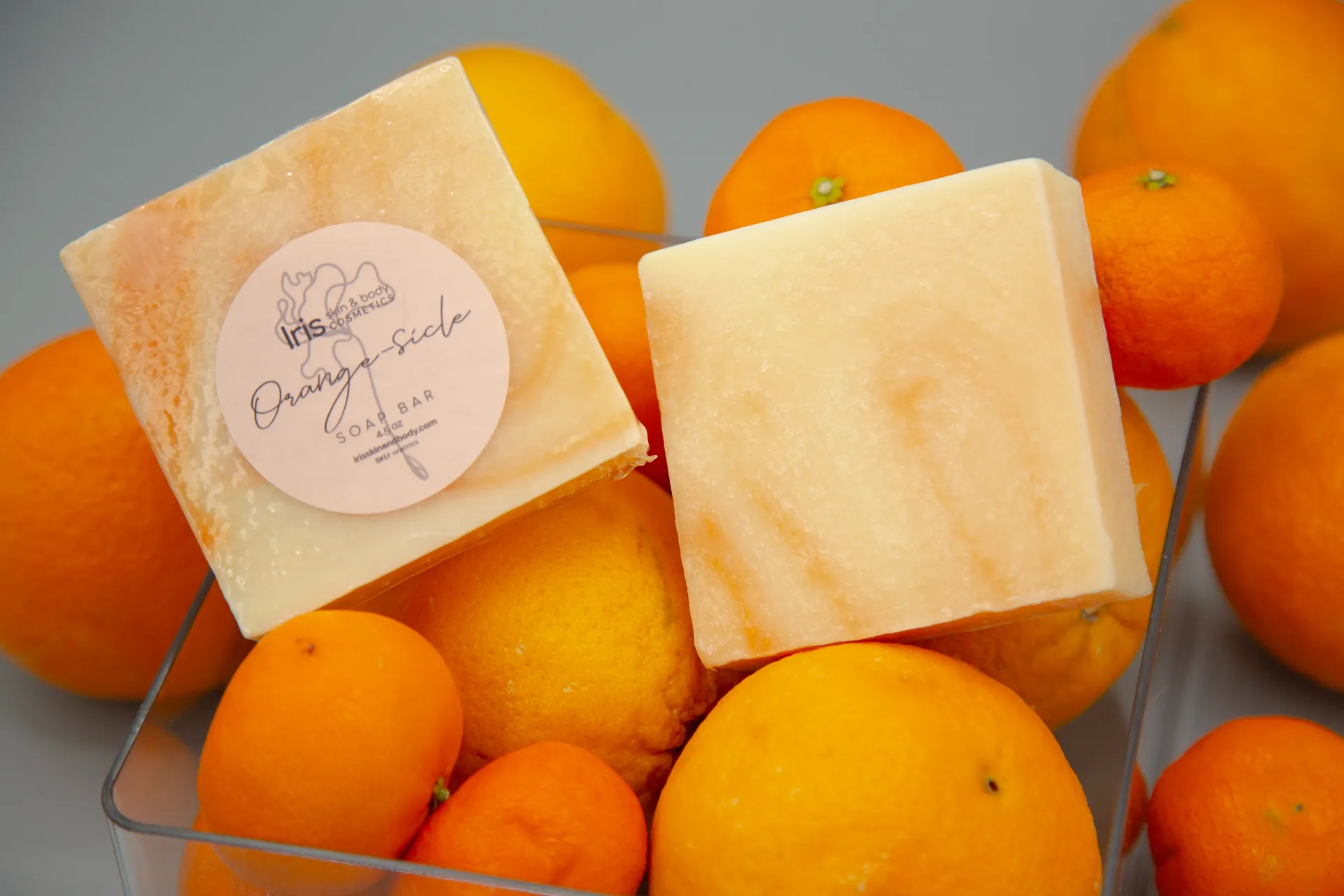 A bar of soap is sitting on top of a pile of oranges.
