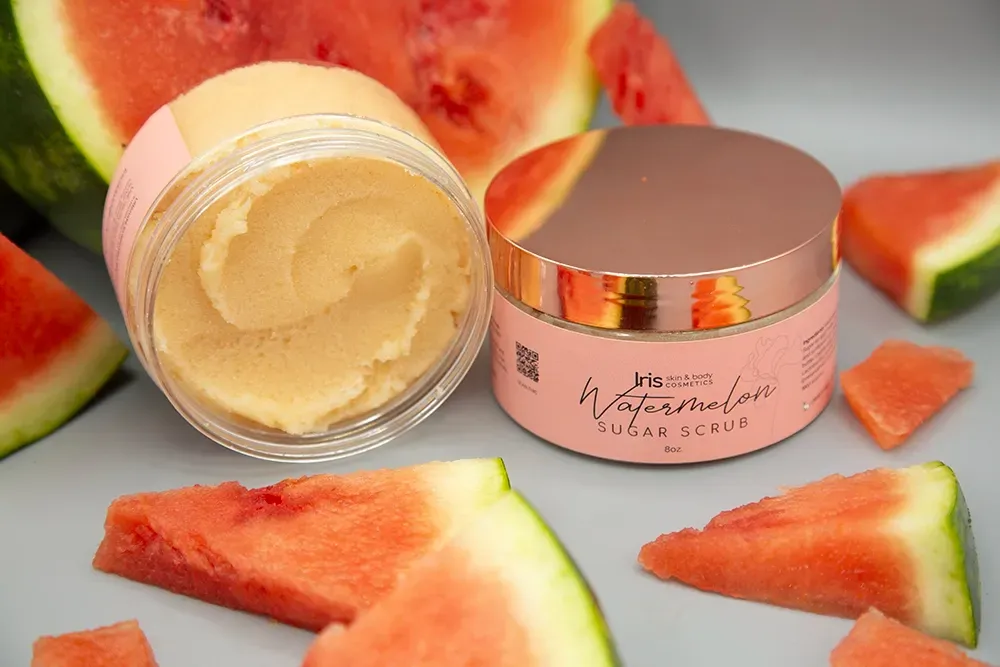A jar of watermelon sugar scrub is surrounded by watermelon slices.