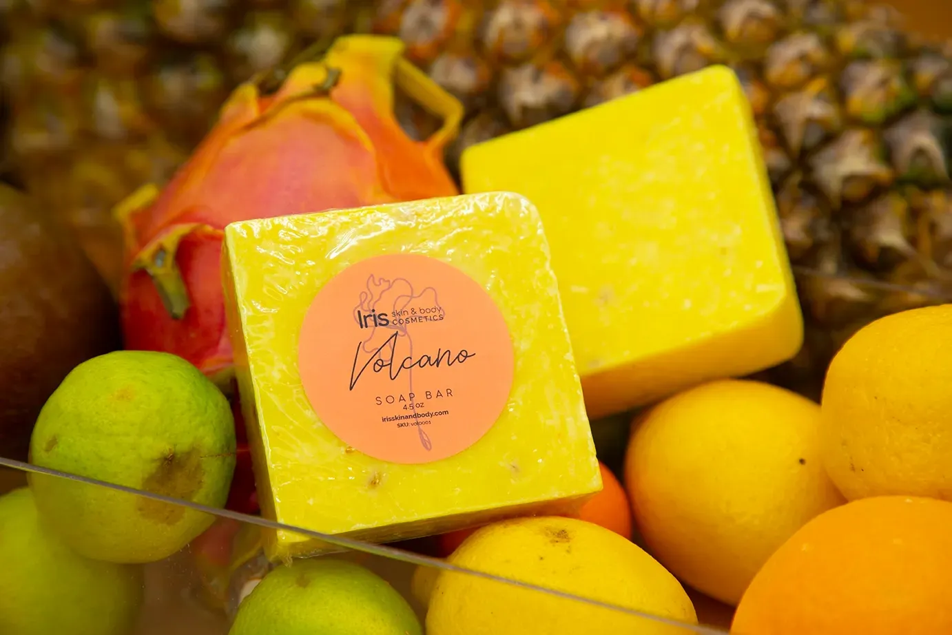 A yellow soap bar is sitting on top of a pile of fruit.