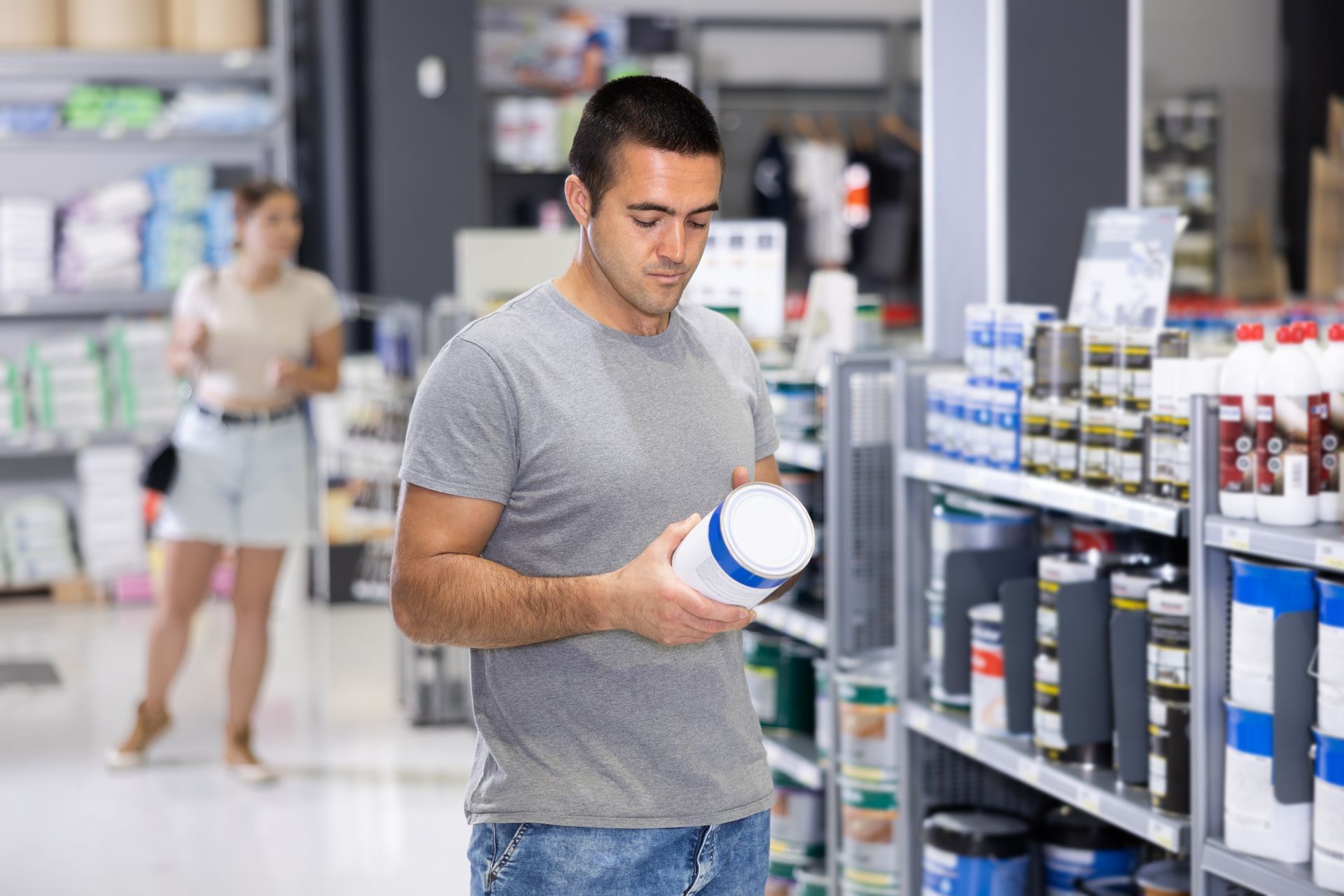 A man examines a product while shopping at one of his local professional paint stores.