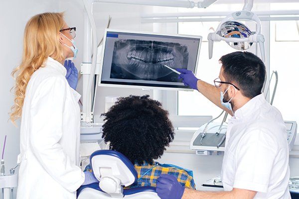 Dentist Explaining Tooth X-Ray to a Male Patient — Albuquerque, NM — New Mexico Endodontic Specialists Dentist Explaining Tooth X-Ray to a Male Patient — Albuquerque, NM — New Mexico Endodontic Specialists