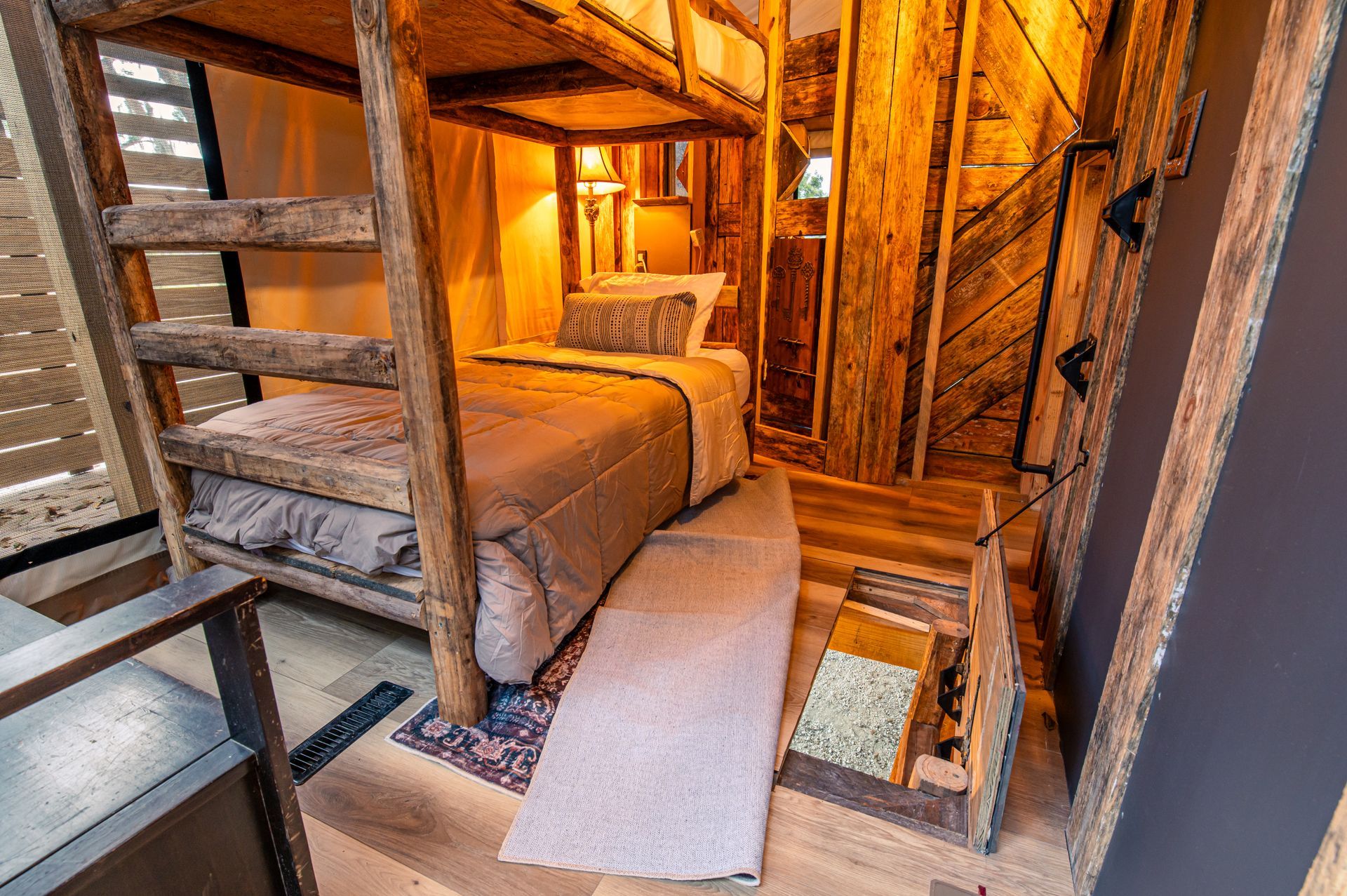 Wooden bunk bed in a rustic-style bedroom, small rug on the floor.