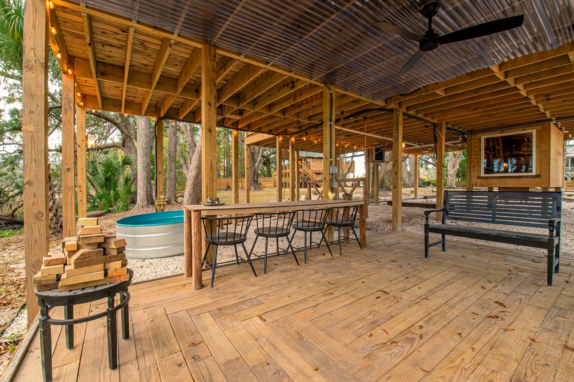 Covered outdoor deck with bar, seating, and small pool.