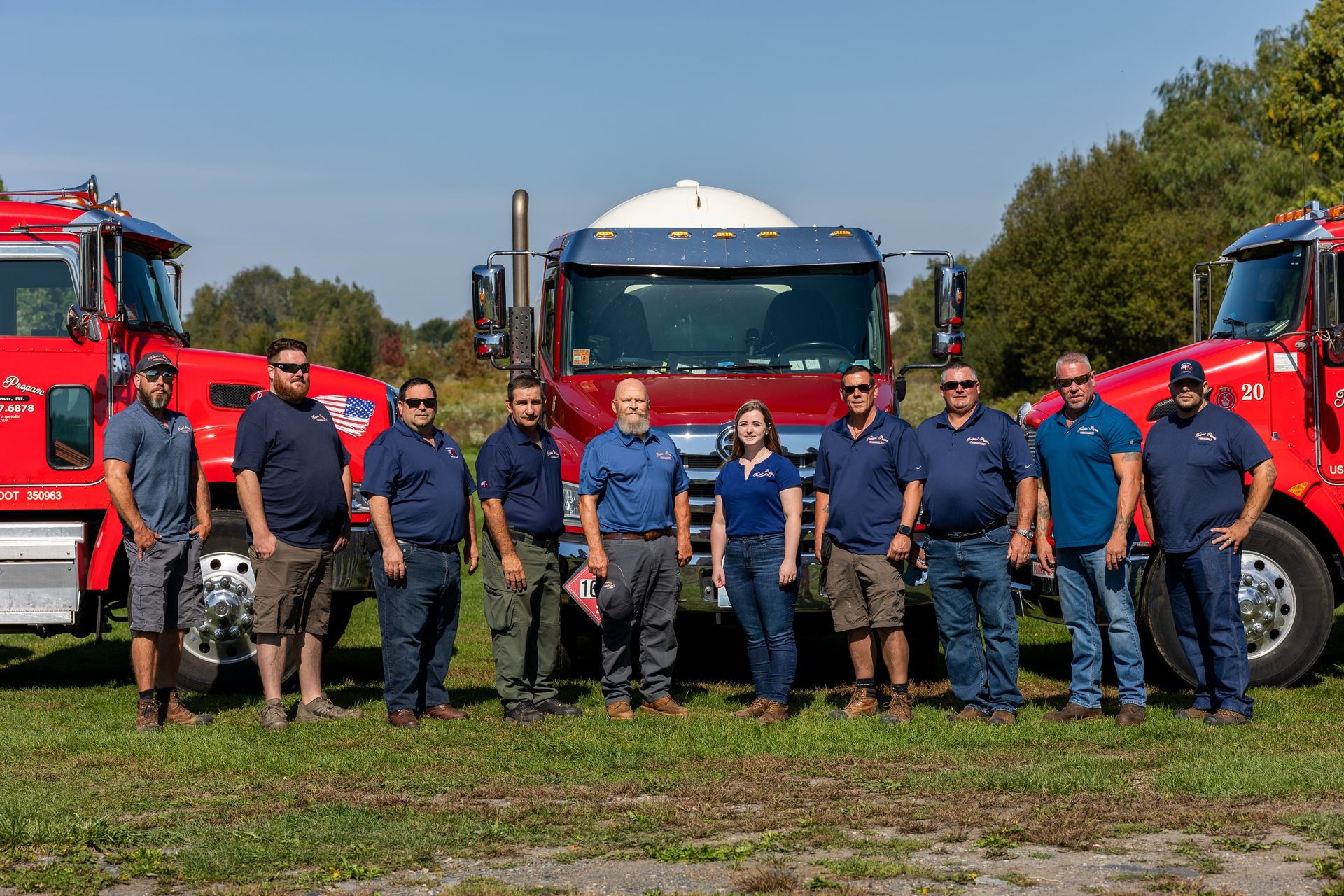 Newport Propane team posing in front of three propane tanker trucks