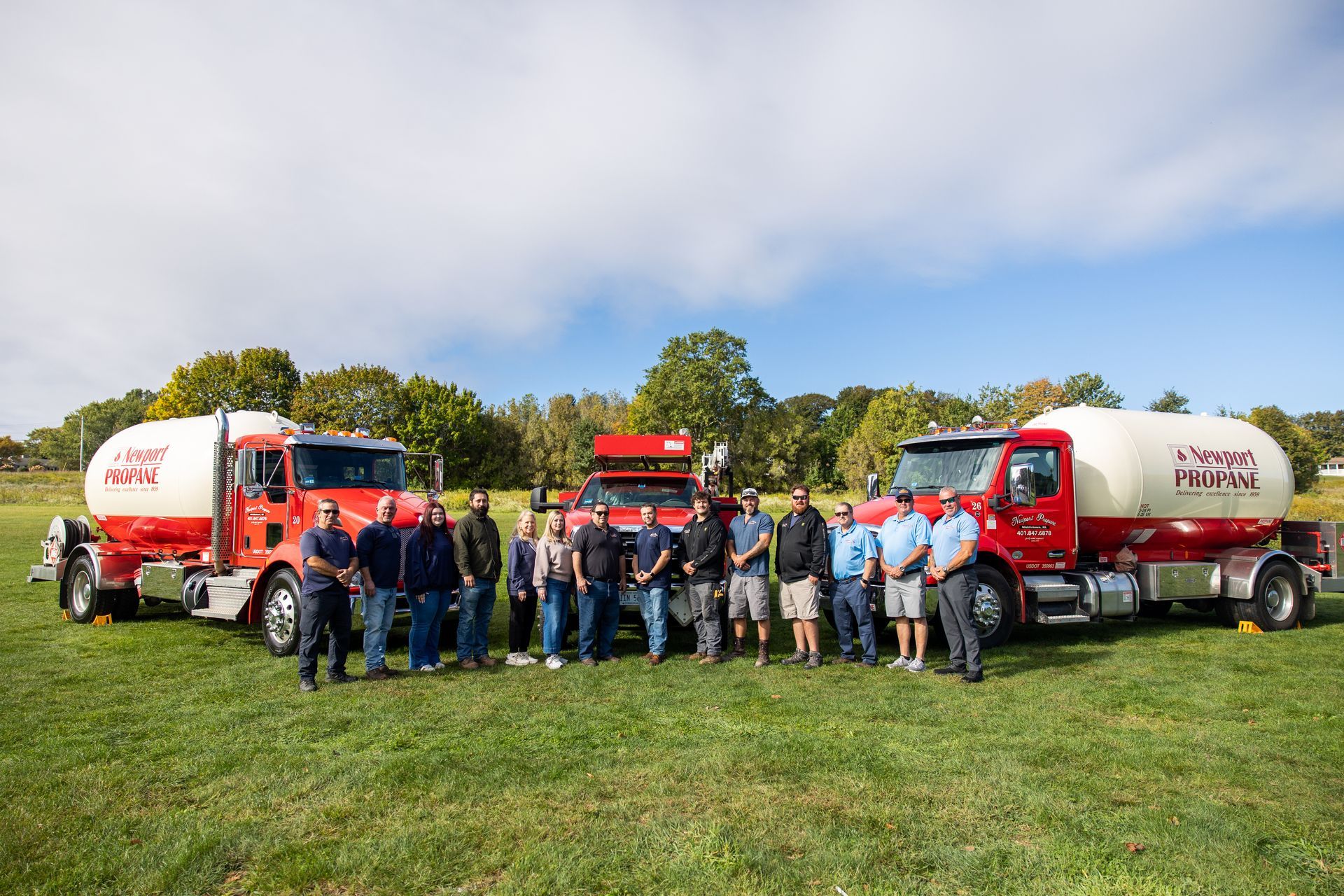 The Newport Propane team standing in front of company propane delivery trucks