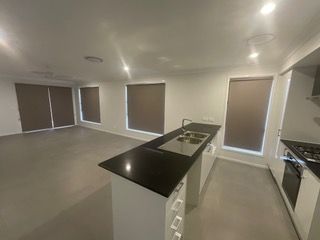 A kitchen with a black counter top and a stove top oven — Plantation Shutters in Singleton, NSW