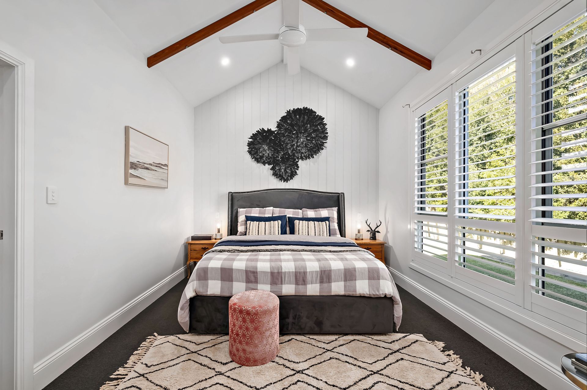 A bedroom with a king size bed and a ceiling fan — Plantation Shutters in Singleton, NSW