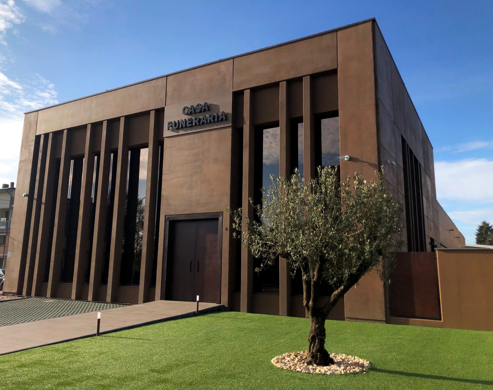 Un grande edificio marrone con un albero di fronte