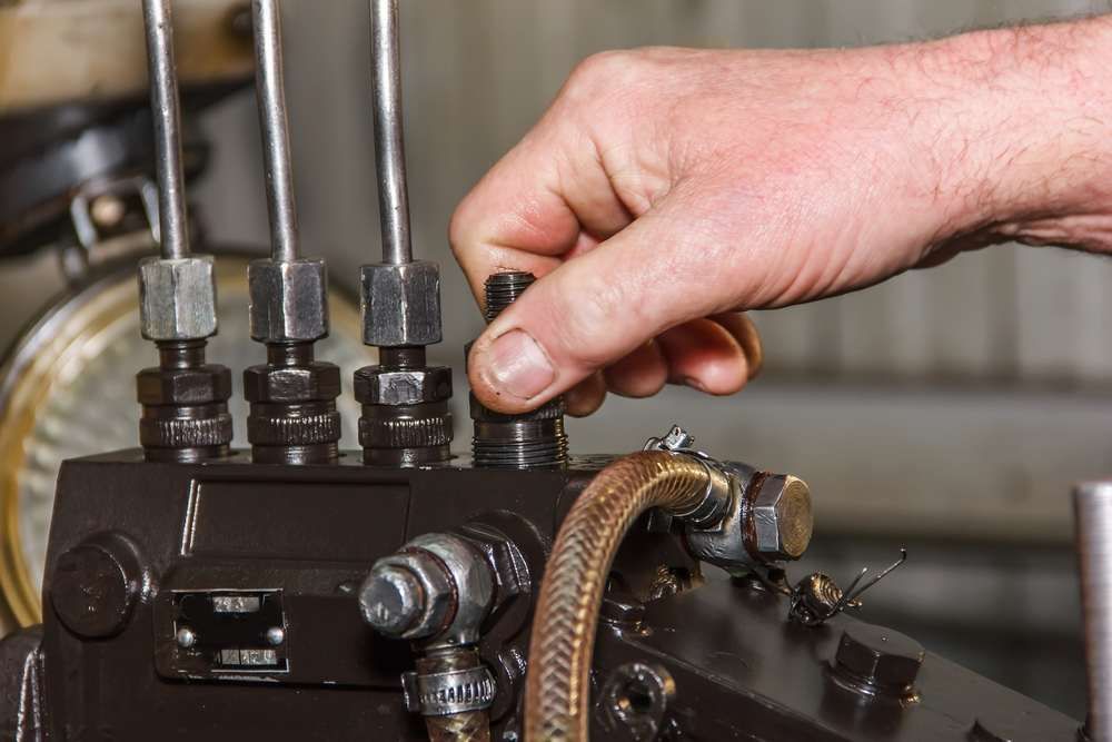 A Person Is Working On A Machine With A Wrench — Baker Automotive In Bungalow, QLD