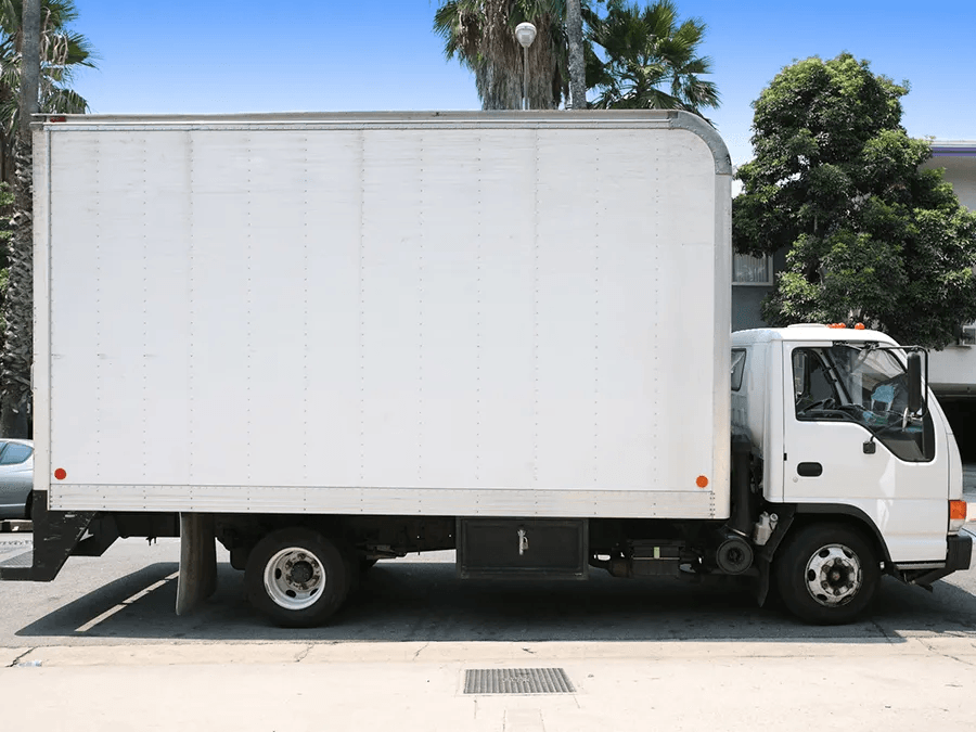 A white moving truck is parked in a parking lot.