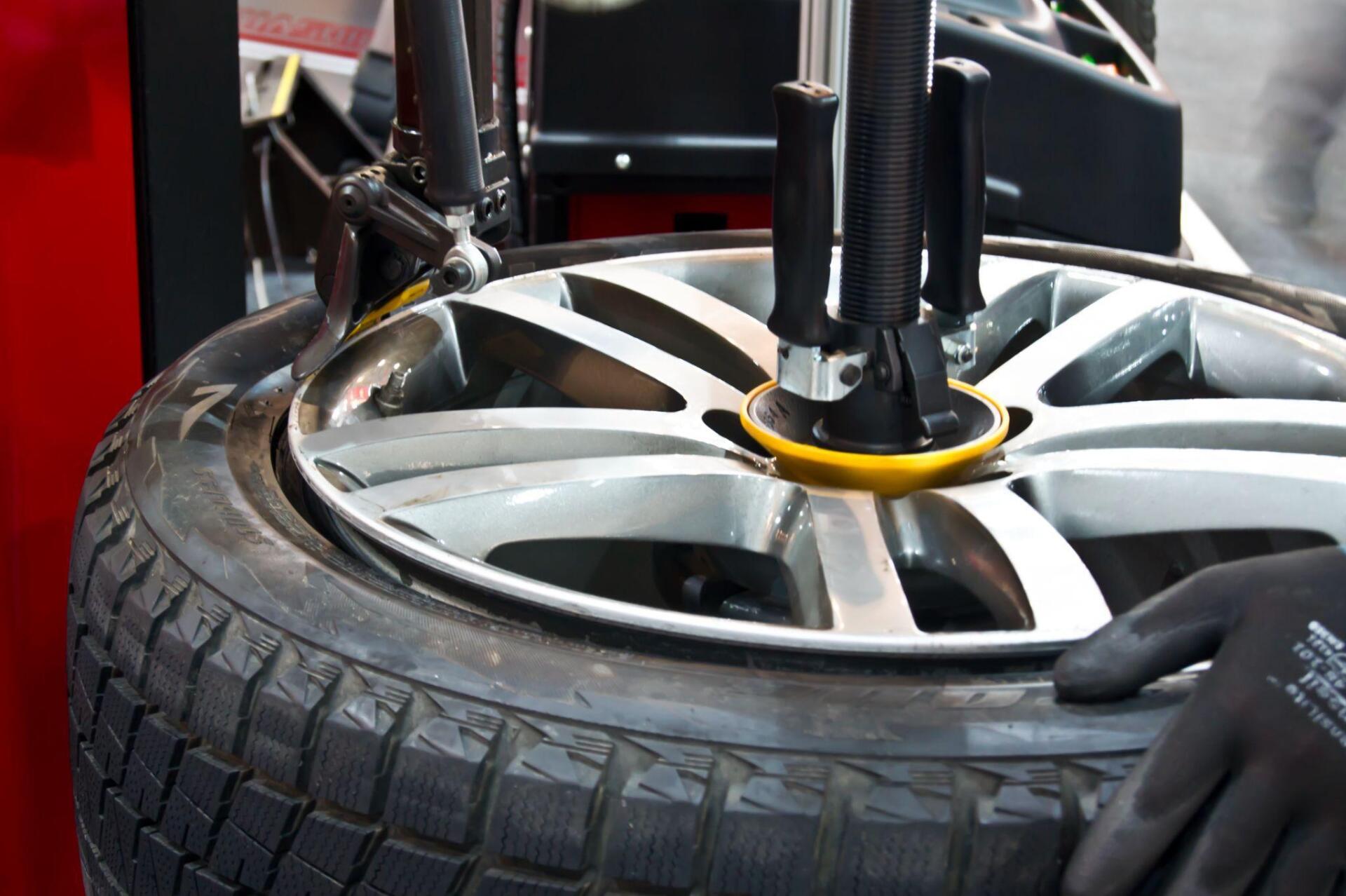 A person is changing a tire on a machine.