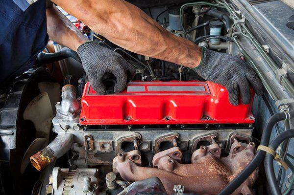 A man is working on the engine of a car.