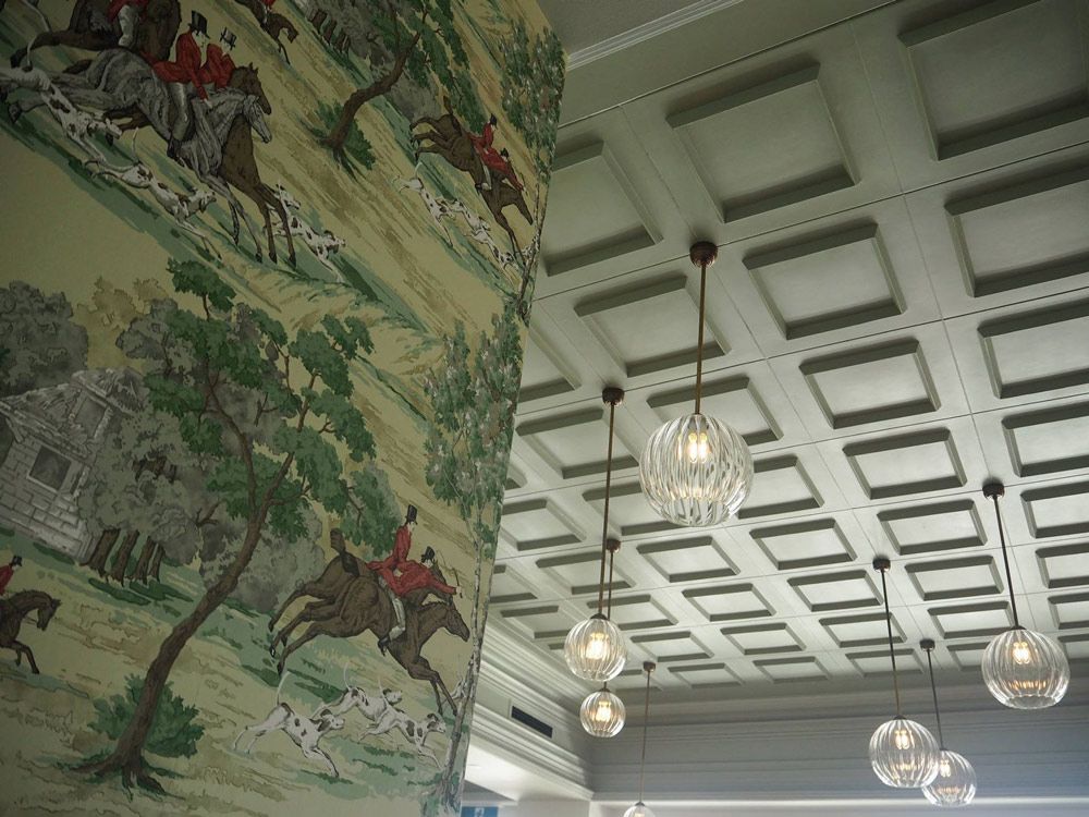 A ceiling with a painting of people riding horses on it