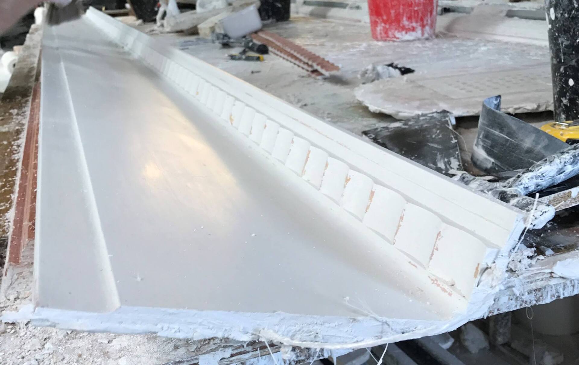 A piece of white molding is laying on a table.