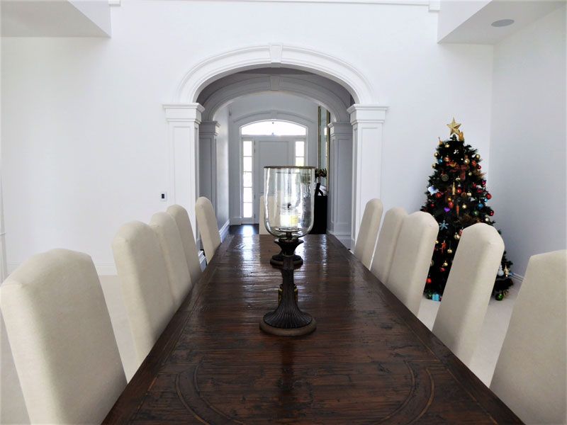 A dining room with a christmas tree in the background