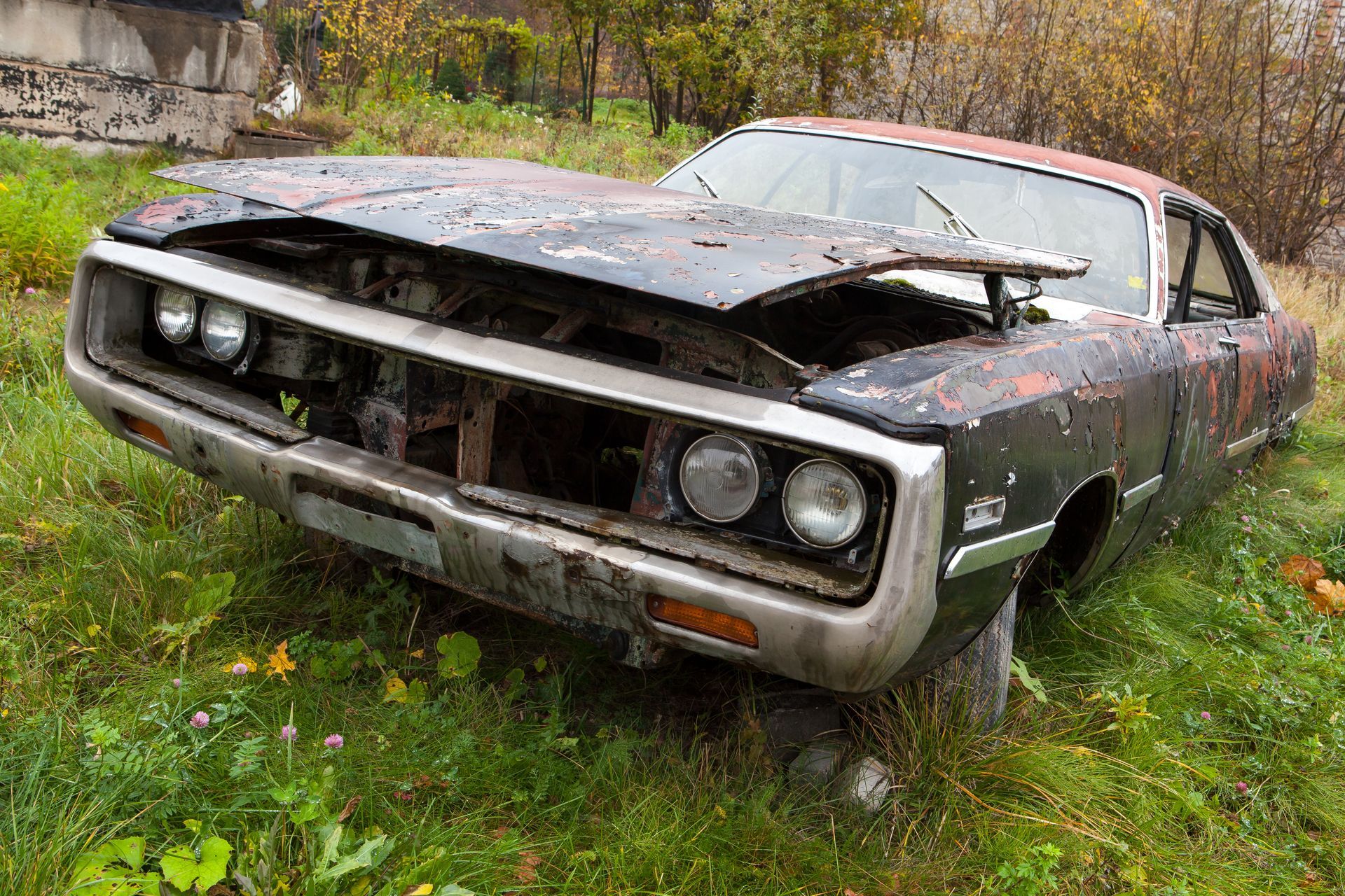 A rusty car sits abandoned, its faded metal and peeling paint showing years of wear. A rusty car sits abandoned, its faded metal and peeling paint showing years of wear.