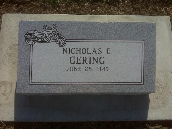 A gray granite gravestone for Nicholas E. Gering, dated June 28, 1949, engraved with a motorcycle graphic.