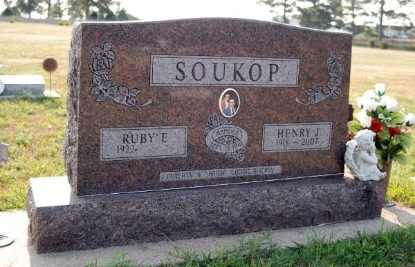 A red granite headstone inscribed 