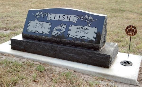 Black upright grave marker for Nancy and Richard Fish with a small metal star emblem on a light stone base.