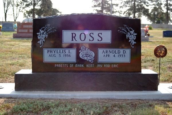 A dark, polished granite headstone for the Ross family, inscribed with names and dates, set in a sunny cemetery.