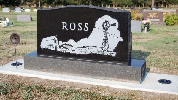A black granite upright gravestone engraved with the name 