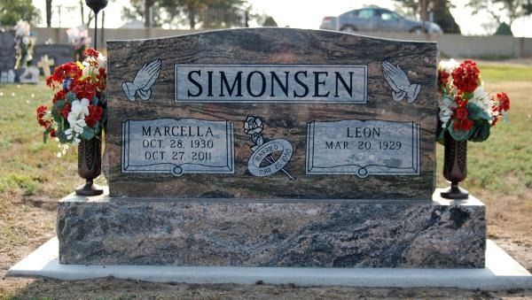 A granite headstone for the Simonsen family in a cemetery, featuring two floral vases and dates for Marcella and Leon.