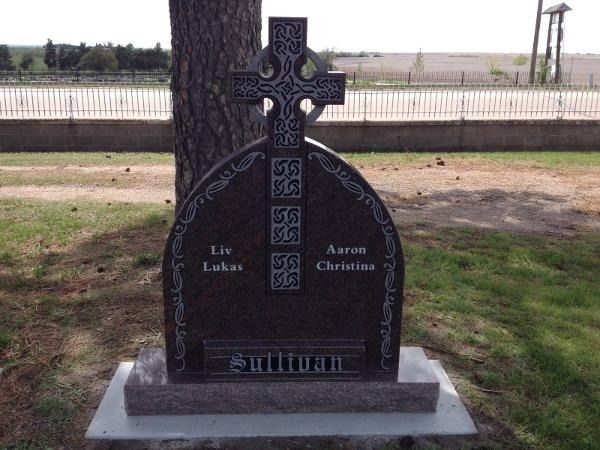 A dark granite headstone engraved with 