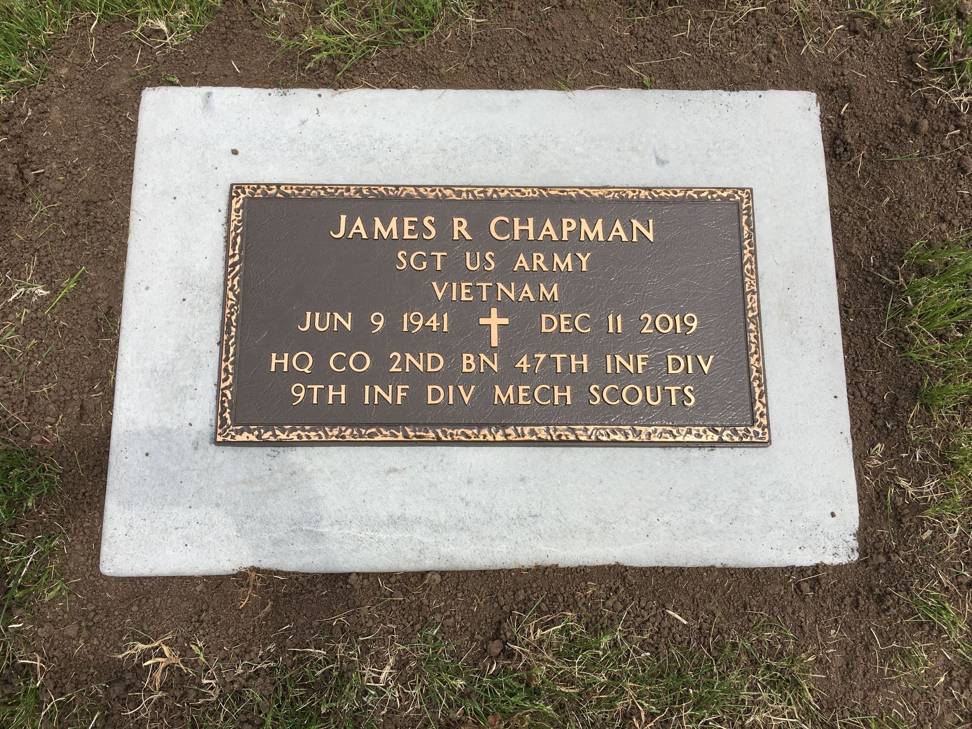 A bronze military grave marker for James R. Chapman, Sgt US Army, Vietnam, set in concrete.