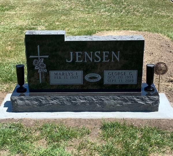A polished black granite headstone with the name 