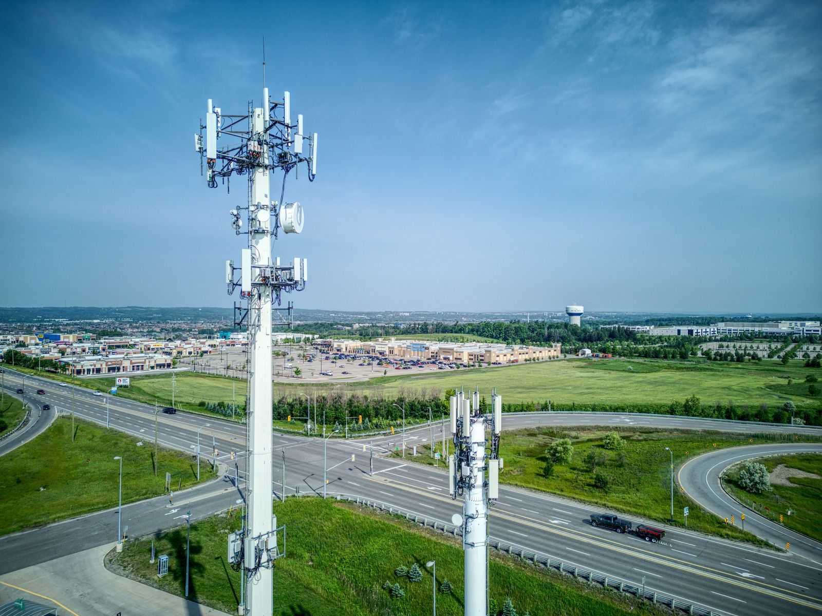 An aerial view of a cell phone tower in the middle of a highway.